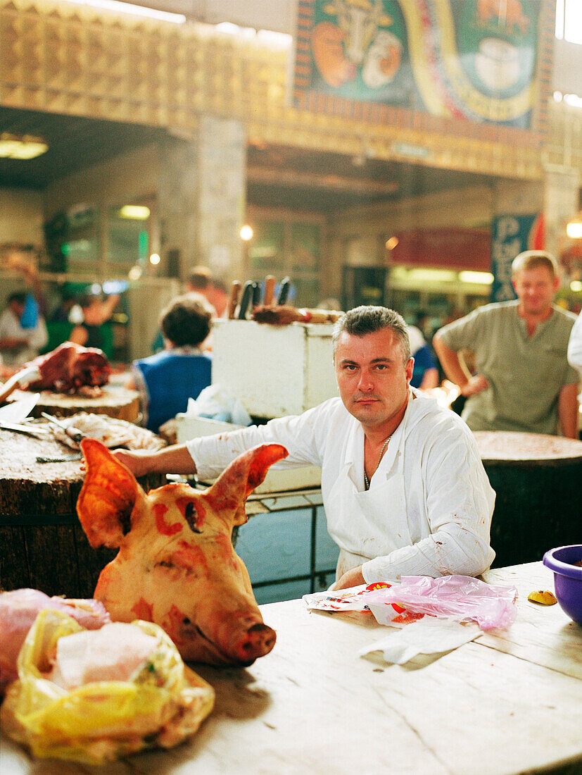 Metzger zeigt Schweinekopf in der Markthalle, Cheryomushkinsky, Moskau, Russland