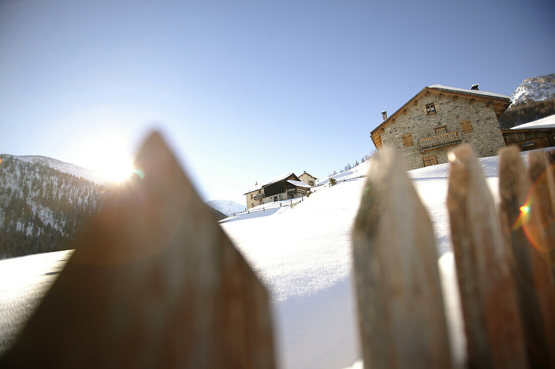 Wooden fence near mountain lodges, alpine huts, Livigno, Italy