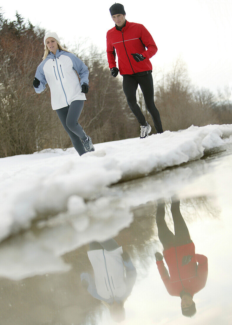 Young couple running at lake