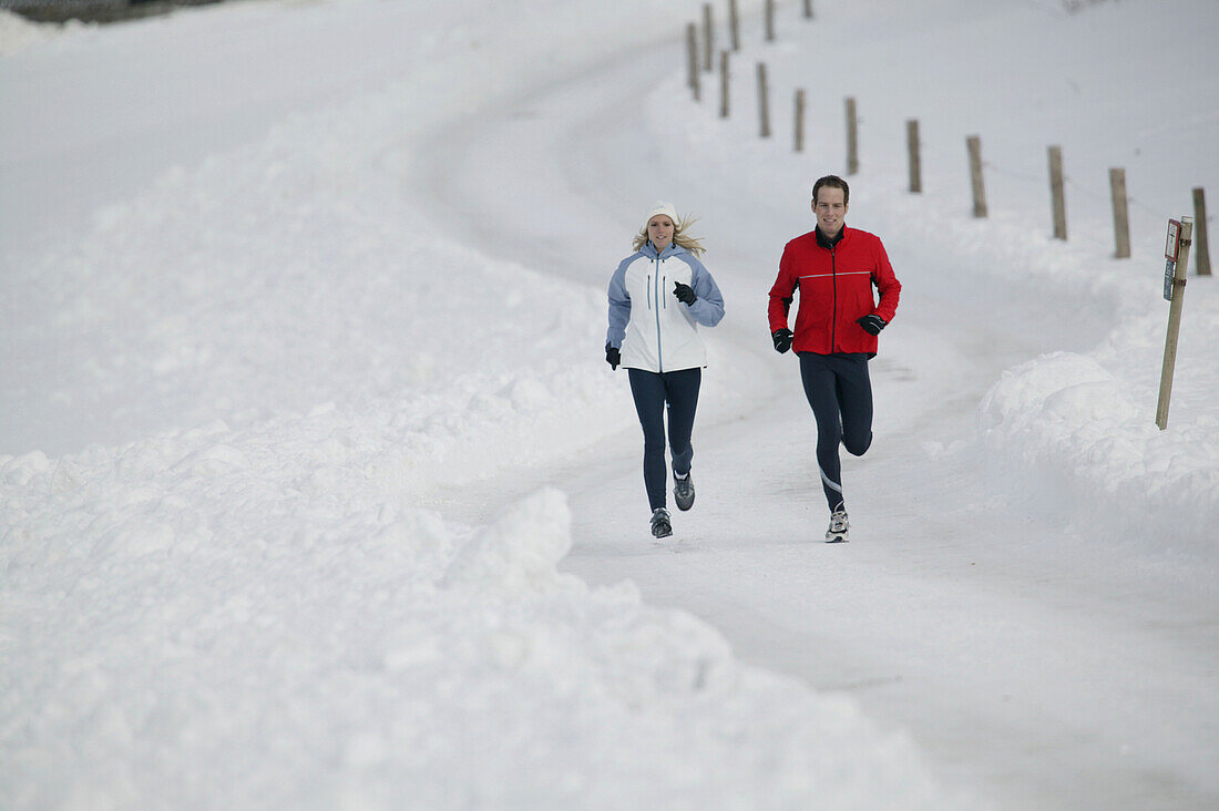 Young couple running on track