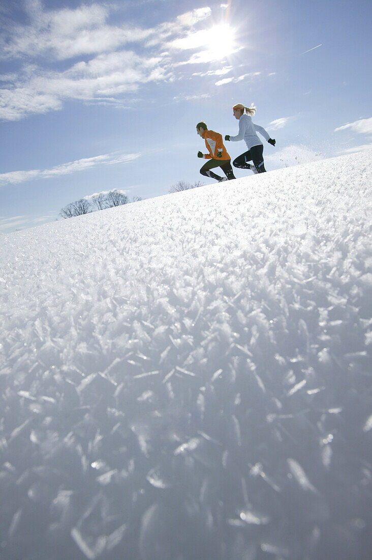 Young couple running through deep snow