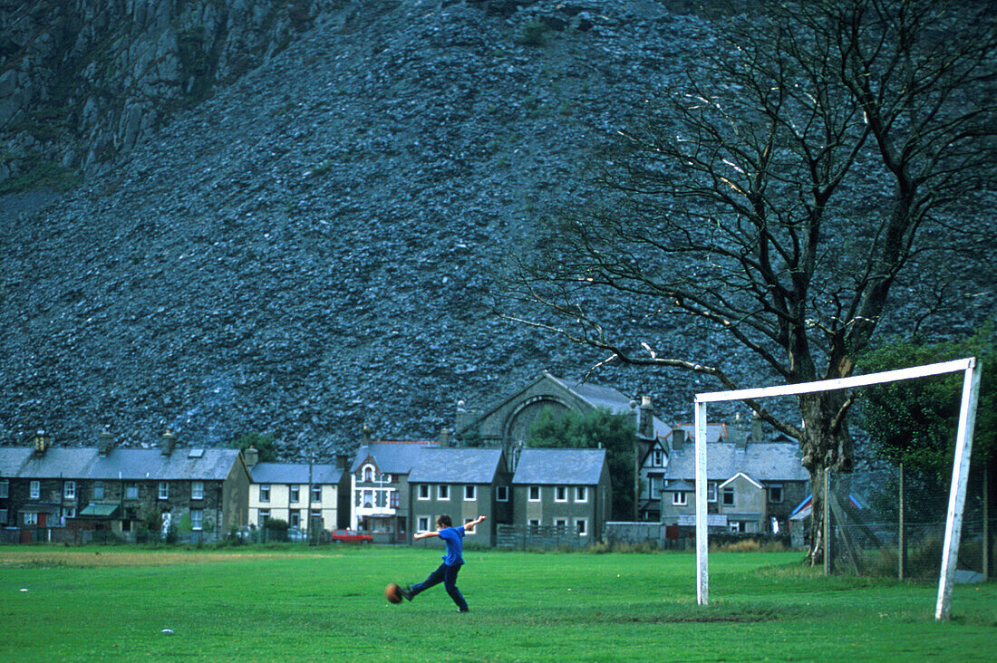 Junge spielt Fußball, Blaenau, Ffestiniog, Wales Großbritanien