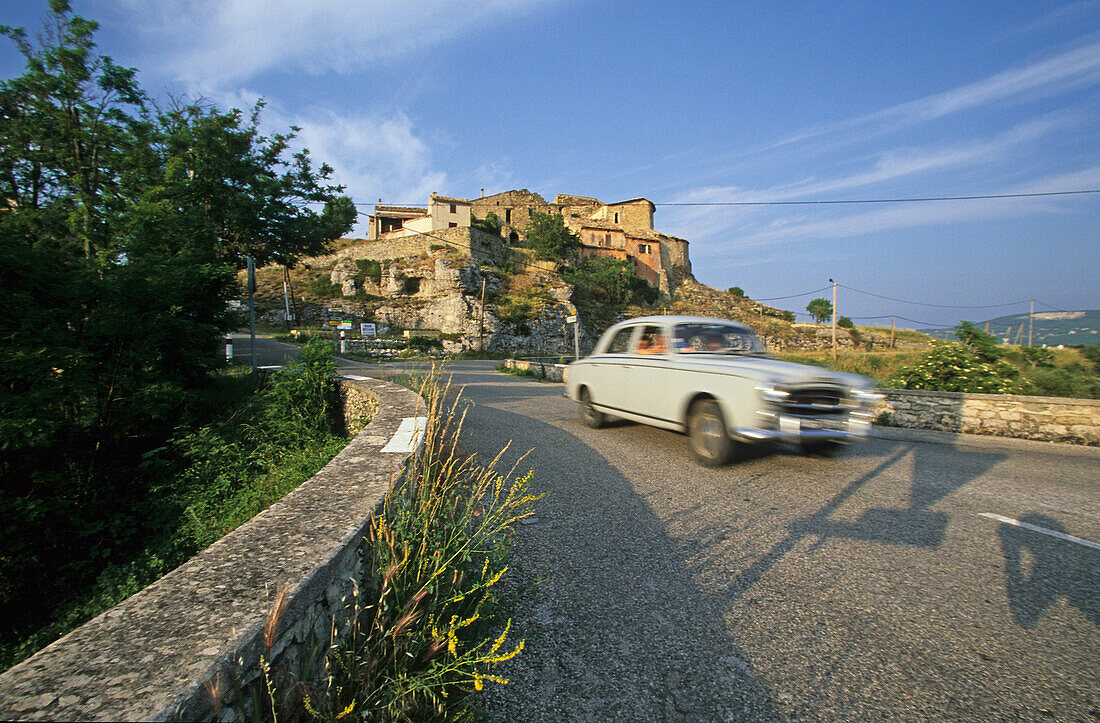 Ein Auto fährt an einem sonnigen Tag auf einer Landstrasse, Ongles, Provence, Frankreich