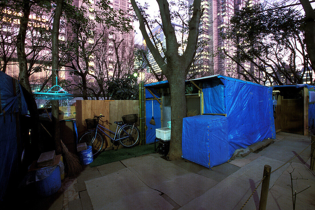 Homeless, living boxes in Tokyo, Japan, Homeless Community below Metropolitan Government Tower, Shinjuku Park Obdachlose, notdürftige Schutzbauten, Pappkarton-Architektur, Plastikplanen, Slum, Obdachlosigkeit, Randgruppe, Astronomical high rents have caus