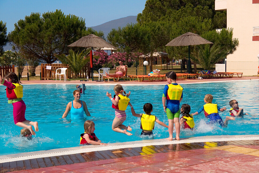 Children jumping into a swimming pool, Kid's Club, San Augustino Resort, Peloponnese, Greece