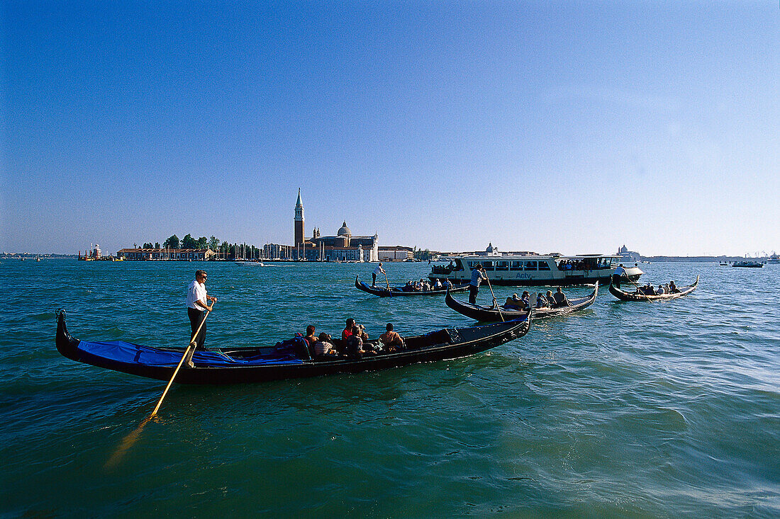 Tourists enjoy a romantic ride in gondolas around Venice. Italy