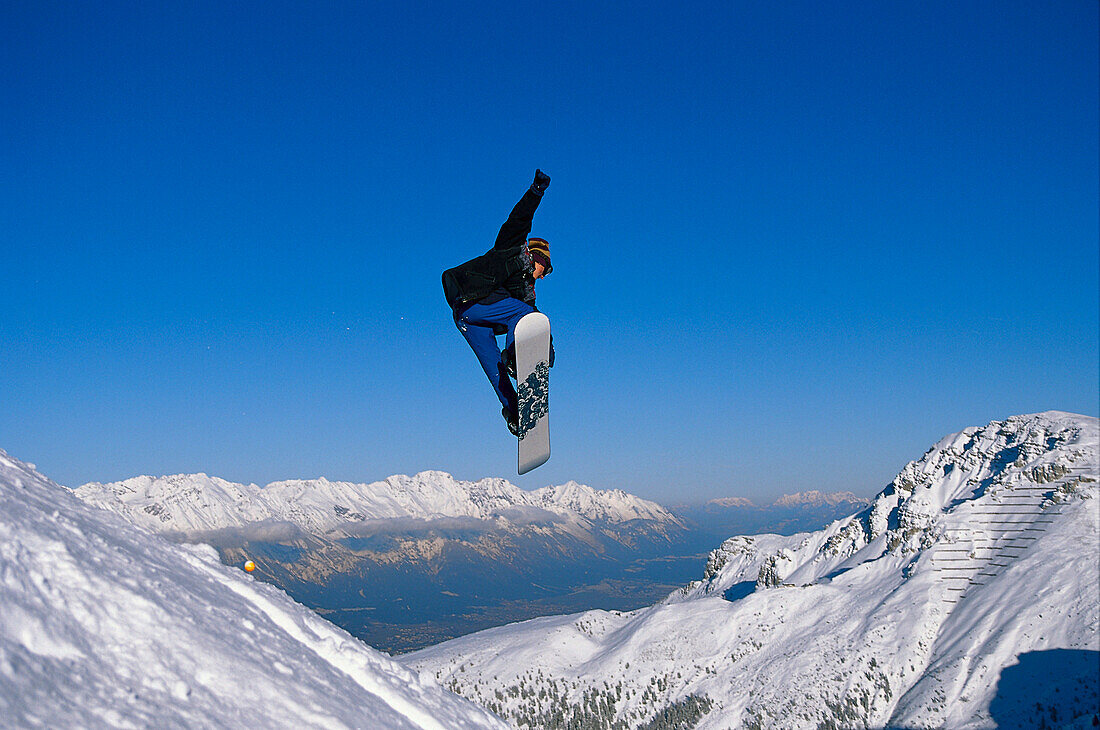 Snowboarder in action, Performing a jump, Innsbruck, Tyrol, Austria