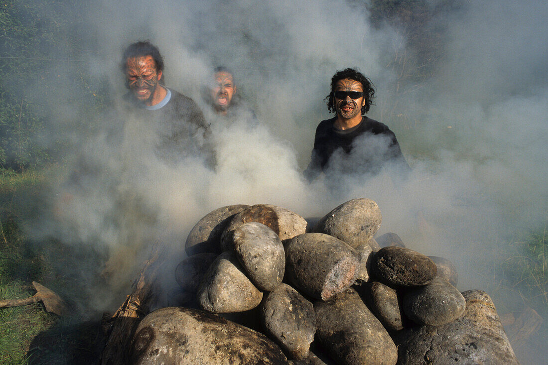 Maori hangi, earth oven East Cape, Maoris with moko tattoo, making an earth oven hangi