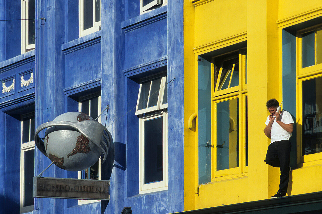 Telephoning outside coloured facade, Man with mobile phone outside building first floor, telefonieren mit Handy am Bunten Gebaudefassade, lifestyle