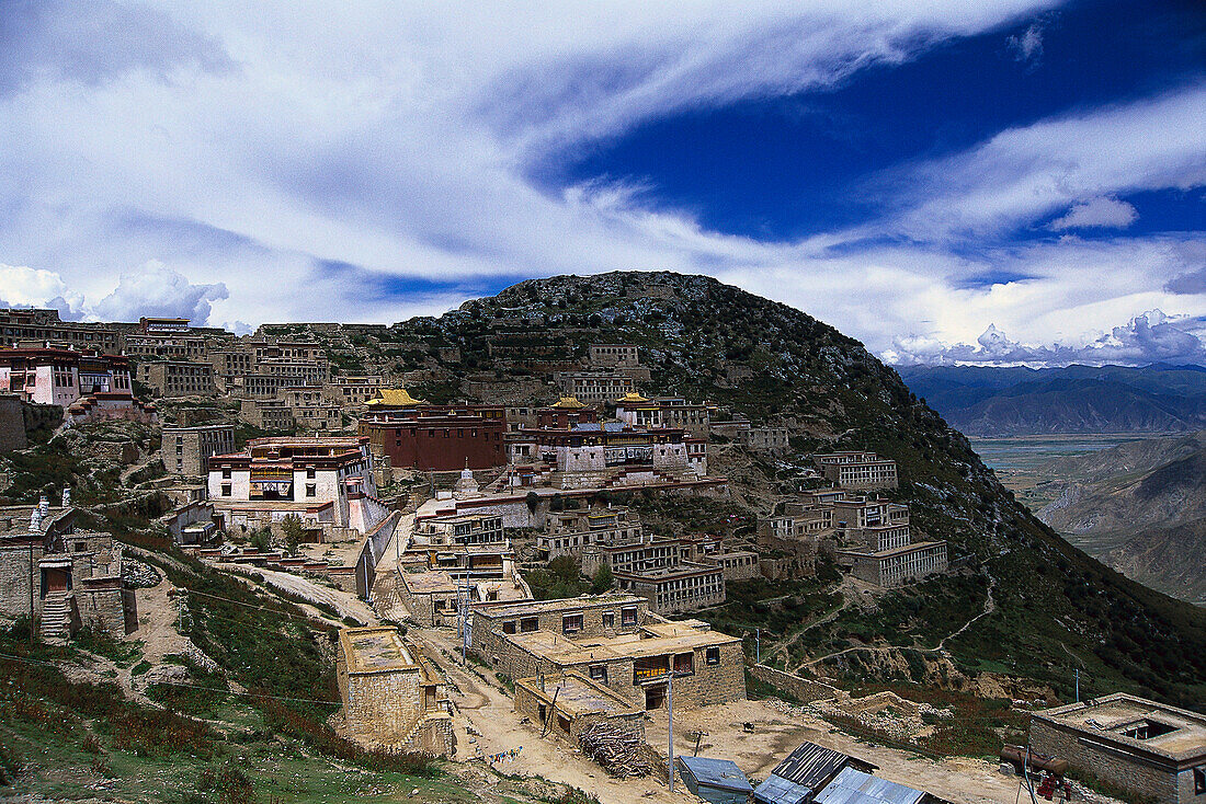 Kloster Ganden an einem Berghang unter Wolkenhimmel, Provinz Ü, Tibet, Asien