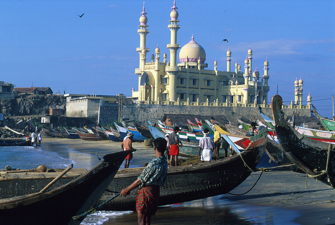 Fishermen and boats on the beach in front of mosque, Kovalam, Kerala, India, Asia