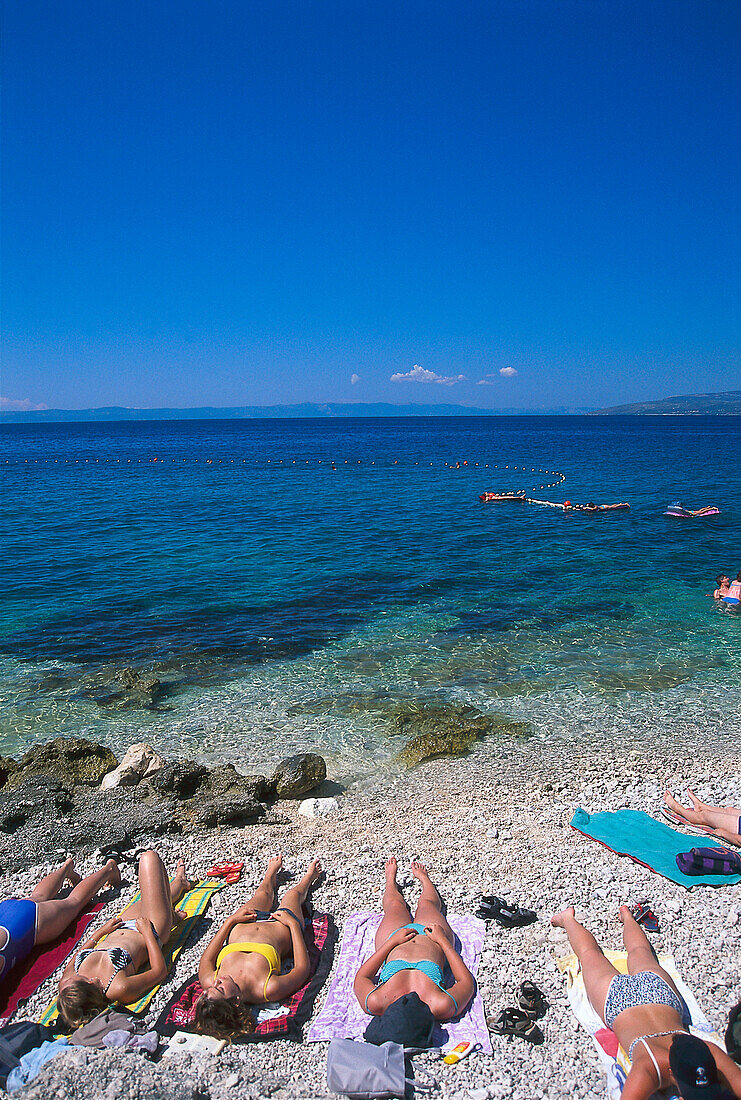 Menschen sonnen sich am Strand an der Makarska Riviera, Kroatien, Europa