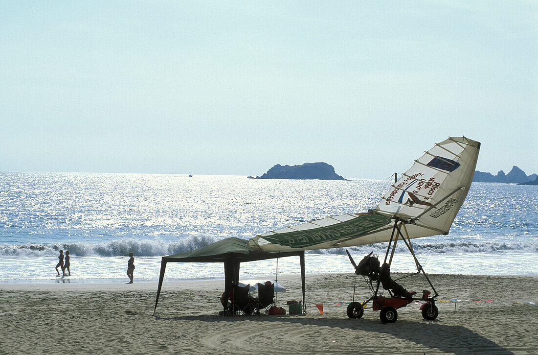 Ultraleichtflugzeug und Menschen am Strand in Ixtapa, Guerreo, Mexiko, Amerika