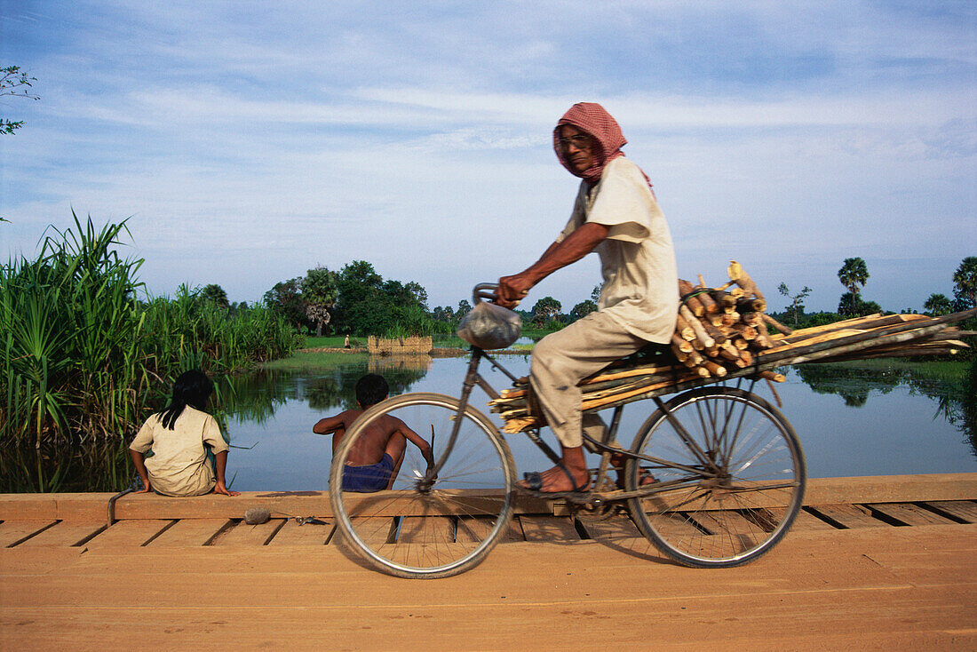 Cyclist on the road to Banteay Srey, , Angkor, Cambodia