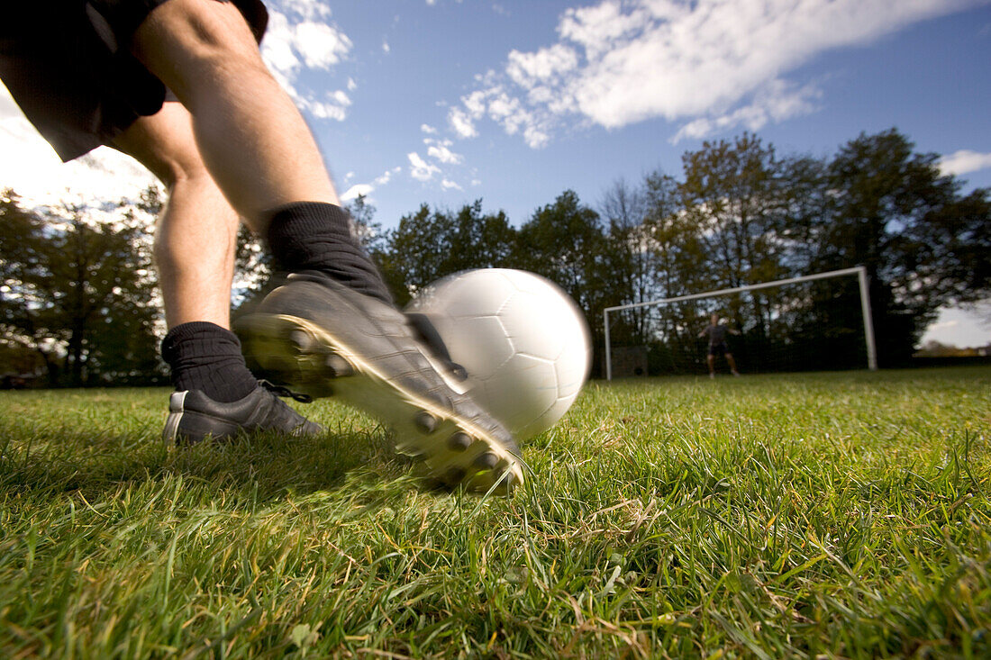 Young soccer player kicking the ball