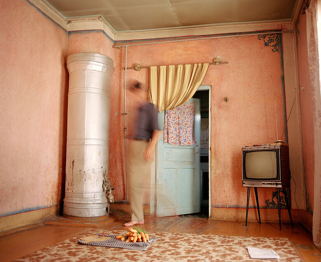 Man standing in living room with ingredients for meal, Uzbekistan
