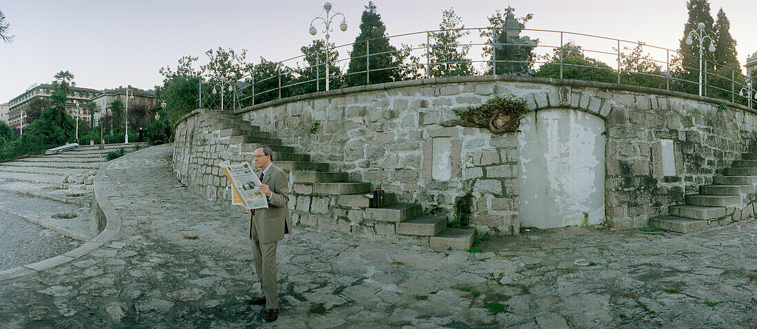 Man reading newspaper in Stresa, Lago Maggiore, Piemonte, Italy