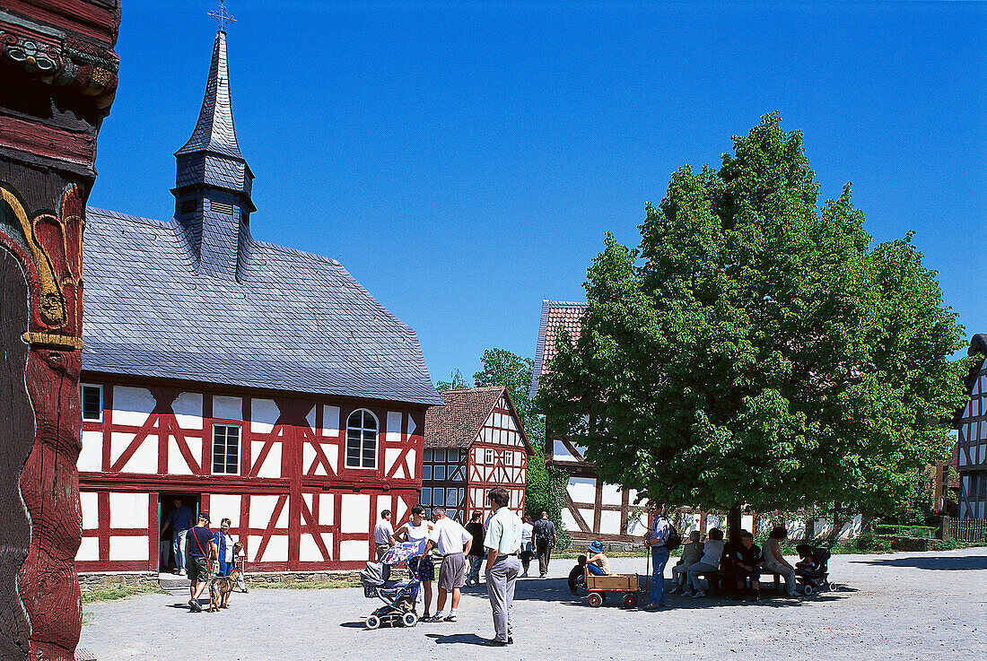 Menschen und alte Fachwerkhäuser im Sonnenlicht, Freilichtmuseum Hessenpark, Taunus, Hessen, Deutschland, Europa