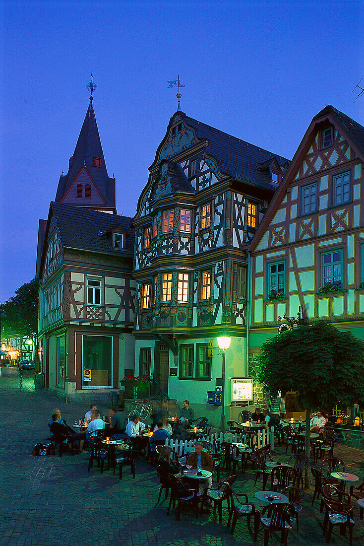 People in a street cafe in front of the half timbered house Killingerhouse in the evening, Idstein, Taunus, Hesse, Germany, Europe