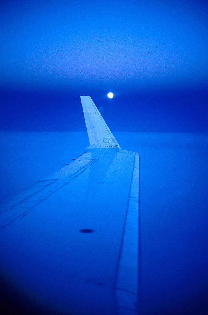 View at wing of an aircraft at moonrise