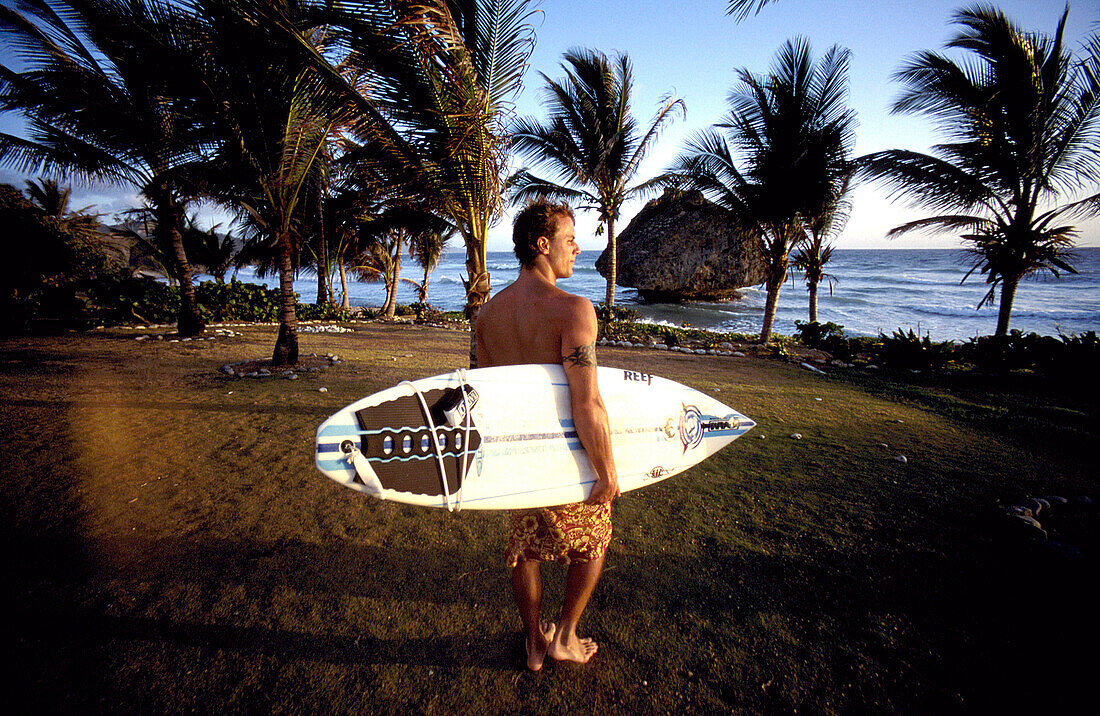 Surfer walking to the sea, Bathsheba, Barbados, Caribbean