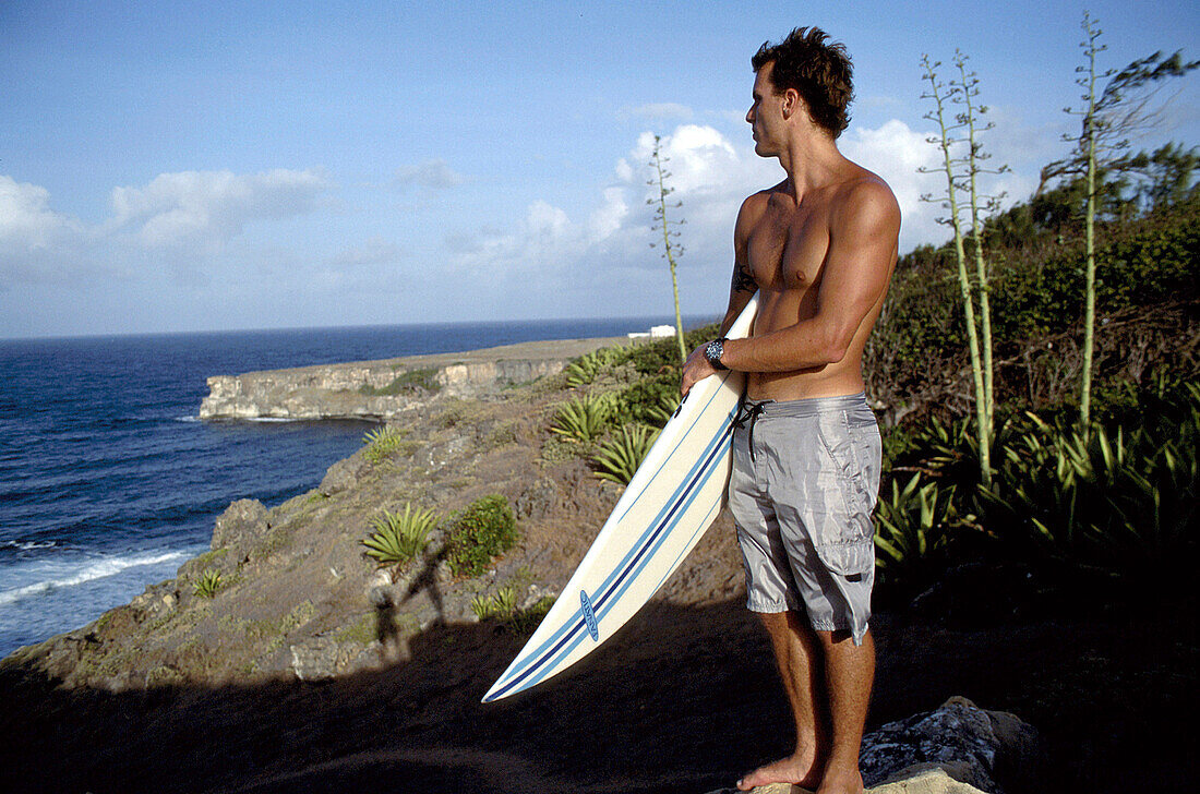 Surfer mit Surfbrett an der Küste, Steilküste, Barbados, Karibik