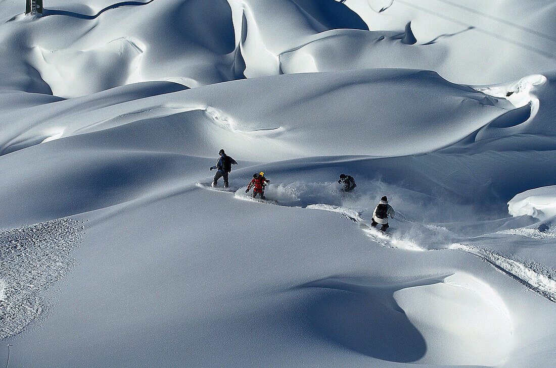Four Snowboarders in powder snow, Lech, Arlberg, Austria