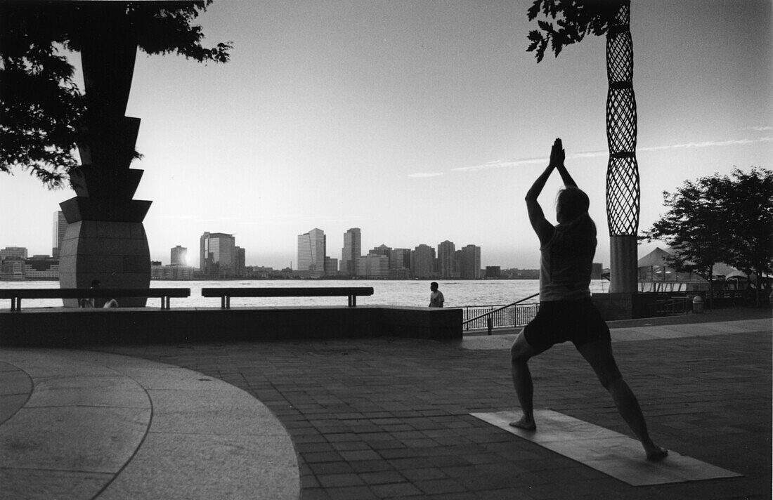 Woman practising Yoga in Battery Park, Manhattan, New York City, USA