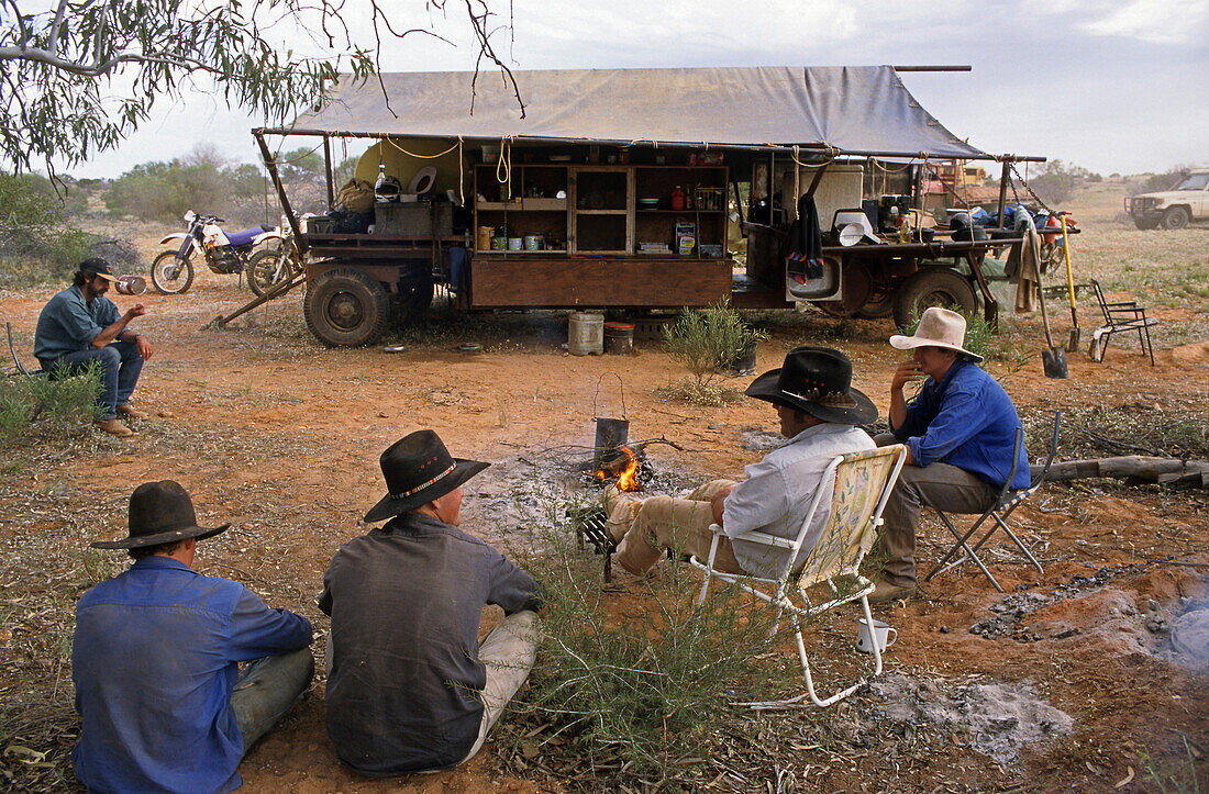 Stockmen sit around the cooks kitchen trailer, Kidman Station, South Australia, Australia