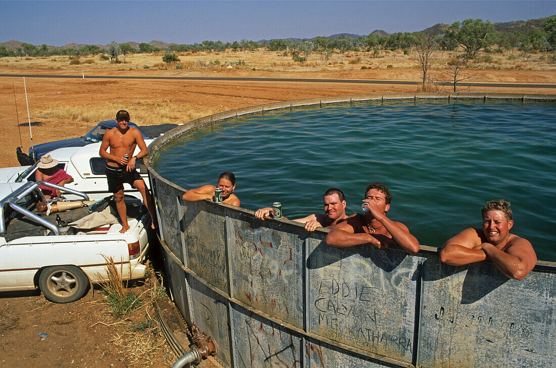 fun cooling off in bore water tank, Kimberley,  West Australia, Australia