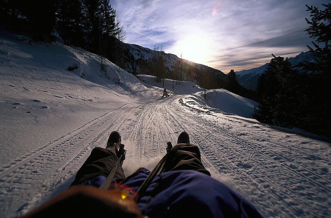 Zwei Personen fahren Schlitten in den Bergen, Staller Sattel, Antholz, Pustertal, Südtirol, Italien, Europa