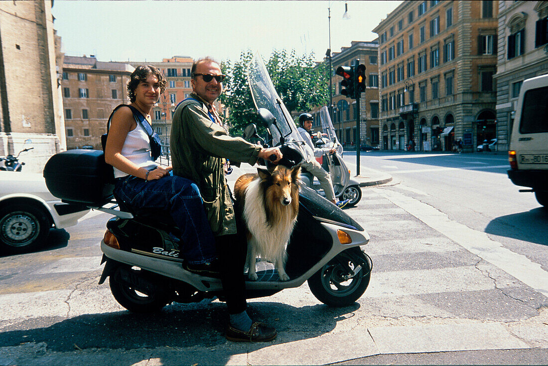 Paar mit Hund auf Motorroller, Rom Italien