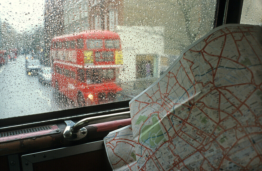 view through rainy bus window with city map, London, England