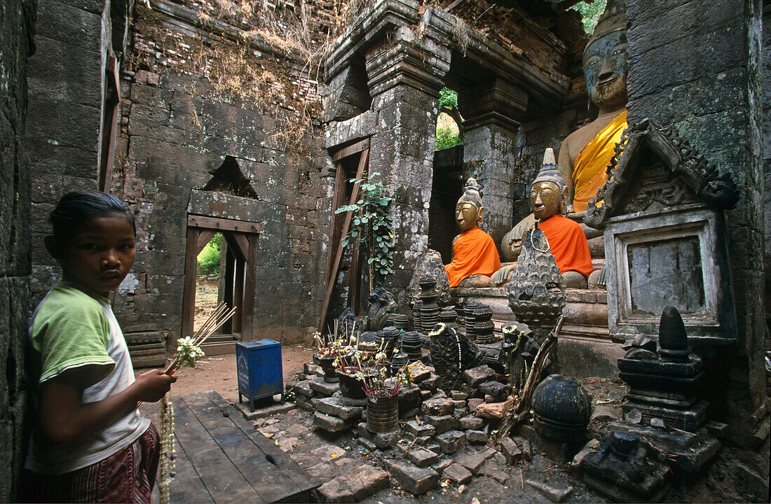 Kind mit Räucherstäbchen in der Tempelanlage Wat Phu, Laos