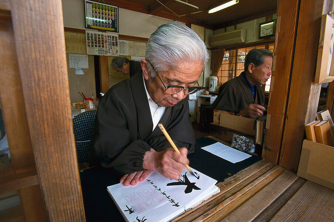 Man doing calligraphy in Kiyomizu-dera temple in Kyoto