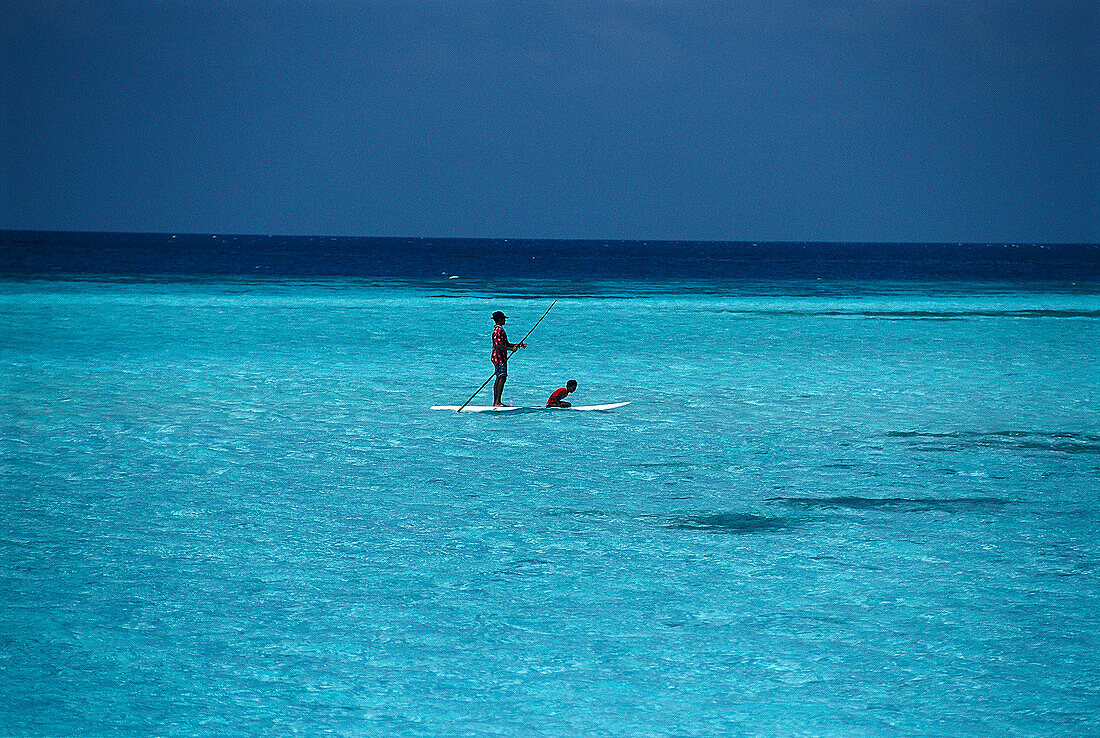 Vater mit Kind auf Surfbrett, Malediven