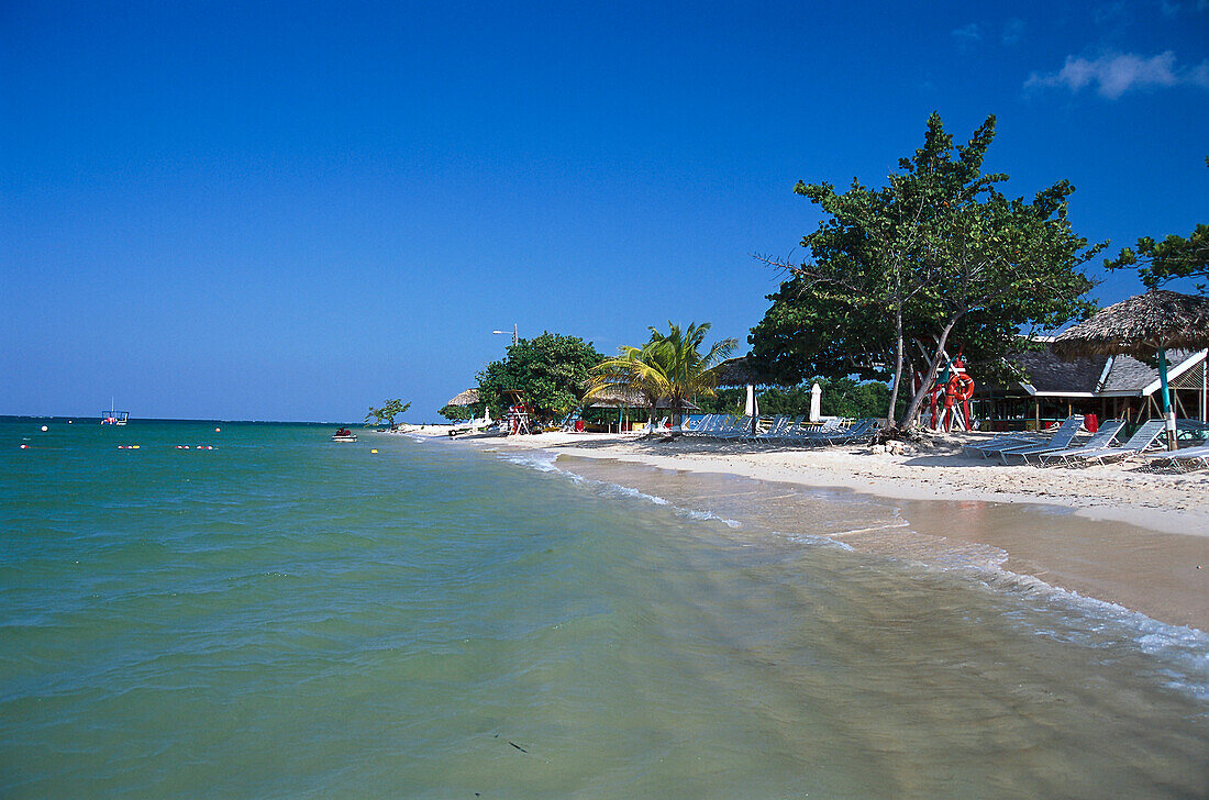 Strand mit Sonnenliegen unter blauem Himmel, Beach Club, Ritz Charlton Rose Hall, Montego Bay, Jamaika, Karibik, Amerika