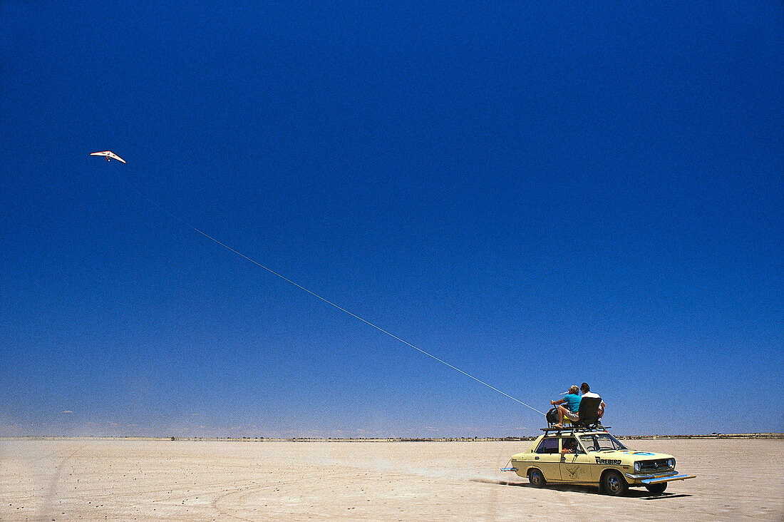 Zwei Menschen auf einem Auto in der Wüste, Drachenfliegen in Namibia, Afrika