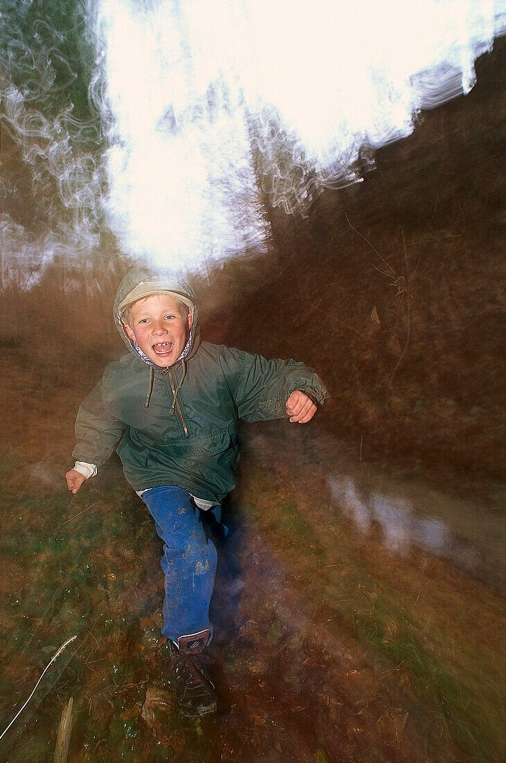 Junge läuft am Waldrand