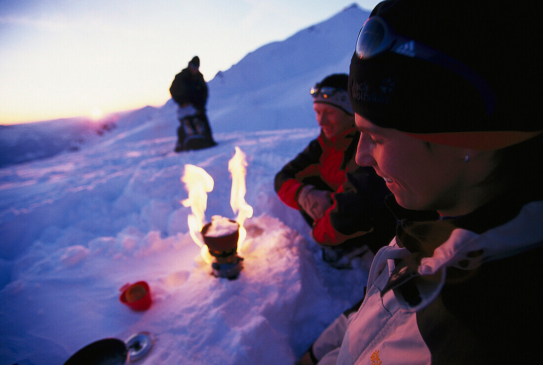 Eine Gruppe Leute sitzen vor dem Campingkocher, Snowshowing Tour, Trekking, Nebelhorn, Allgäuer Alpen, Allgäu, Deutschland