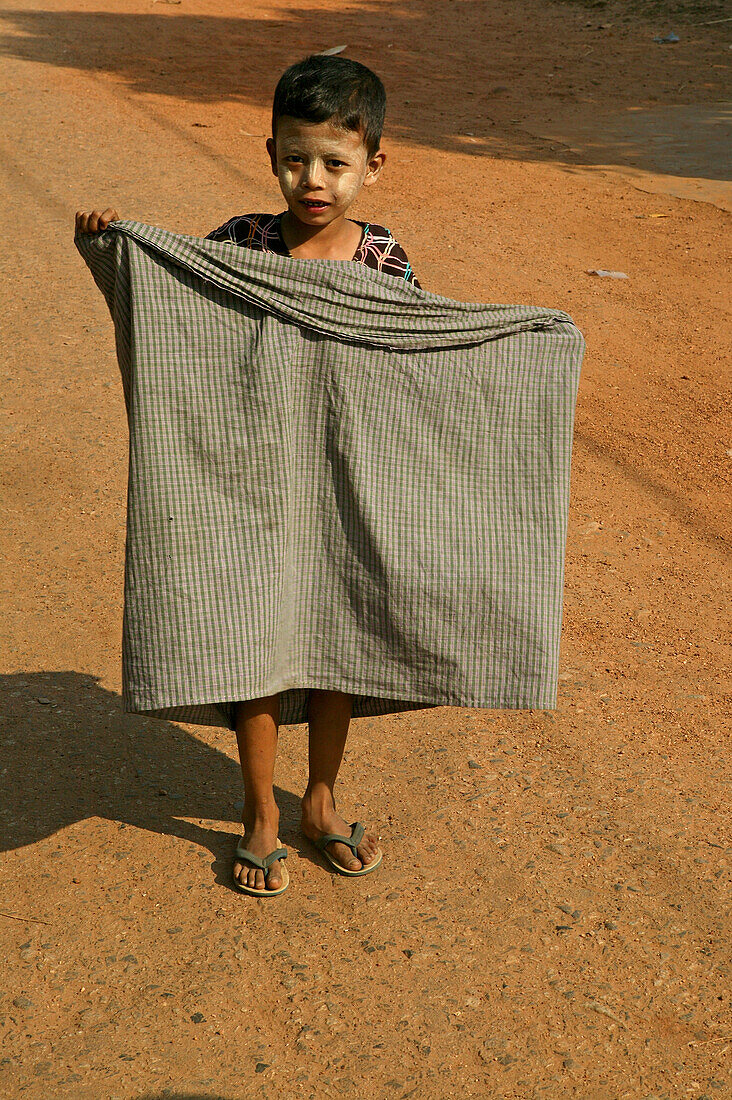 Child wrapping his longyi, Burma, Kind faltet sein Longyi, traditionelle Kleidung, traditional dress