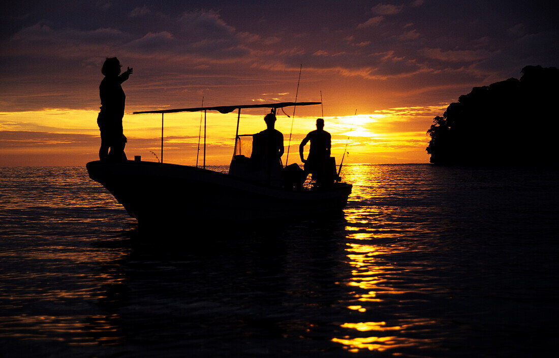 Young people in a boat at sunset, Tallillis, Rabaul, East New Britain, Papua New Guinea, Melanesia, PR