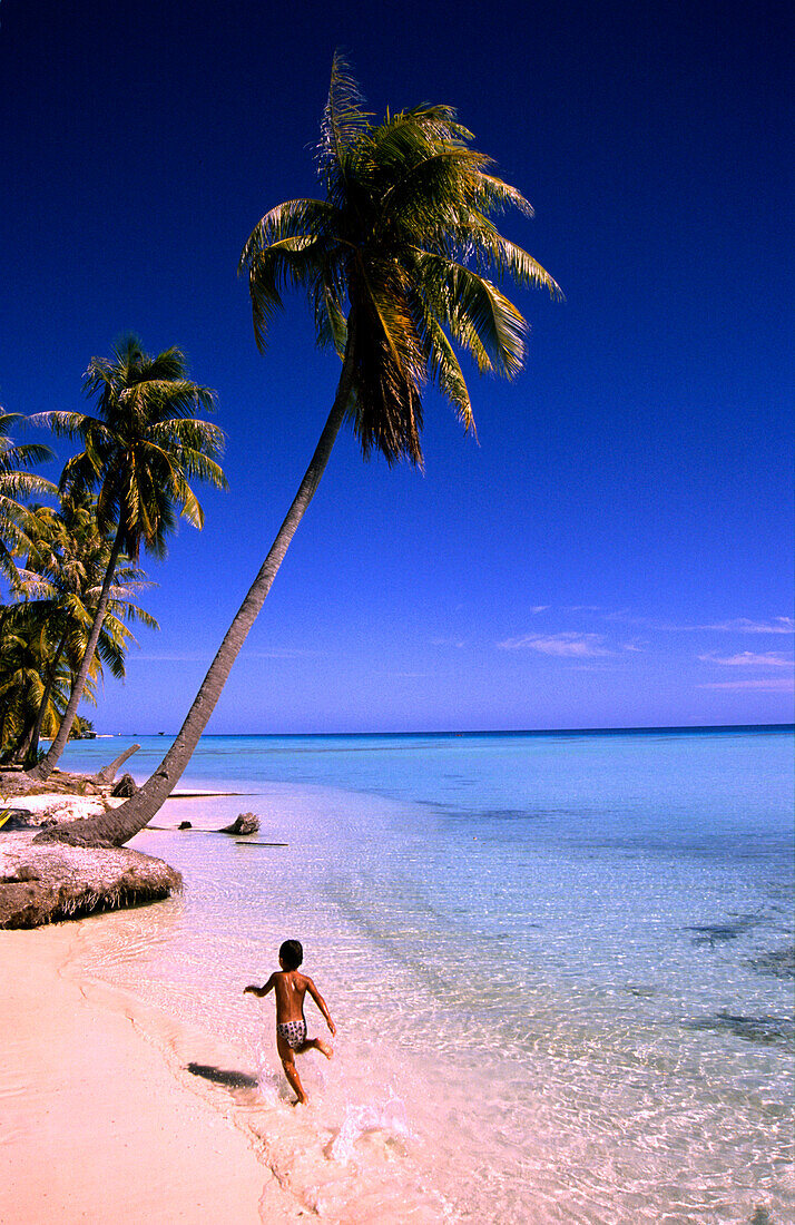 Boy running along the beach, Paradise Beach, Makemo, Tuamotu Islands, French Polynesia, South Pacific