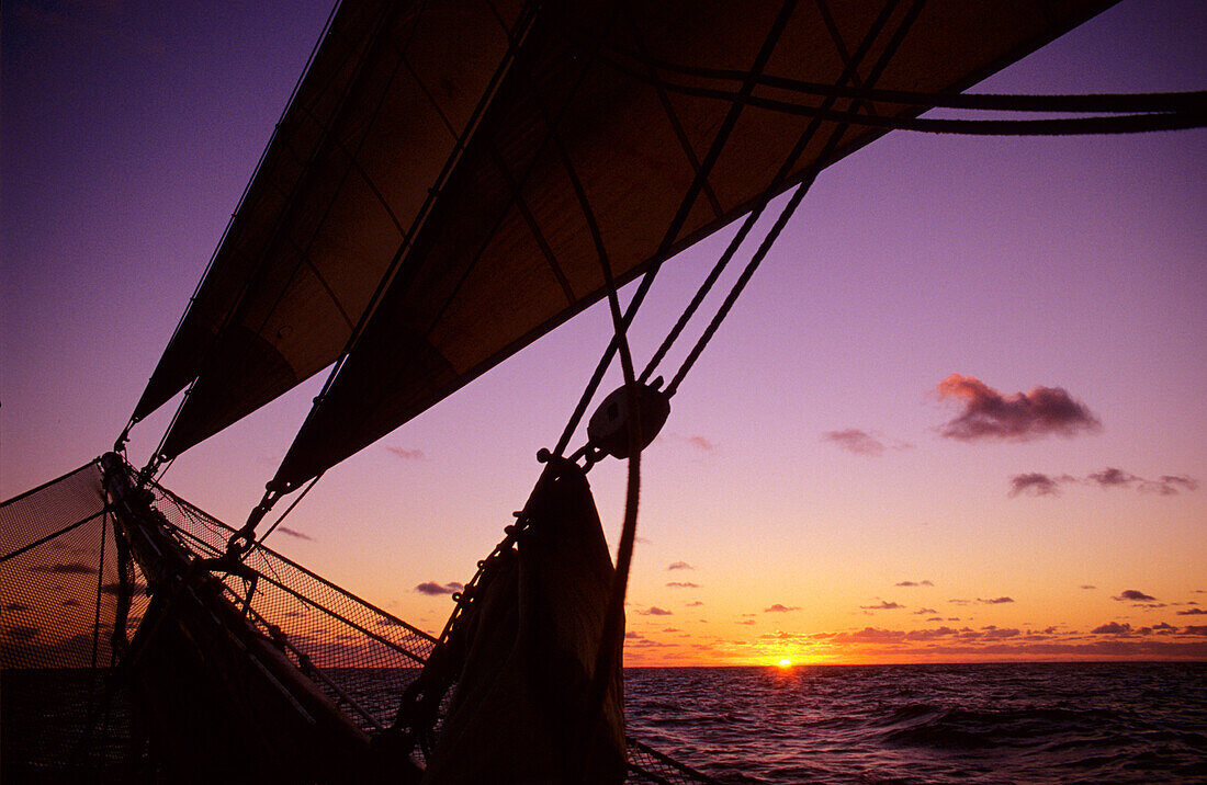 Romantik Sonnenuntergang am Horizont mit Bugspriet und Bugnetz im Vordergrund, Traditional sailing Ship, Ozean, Südsee