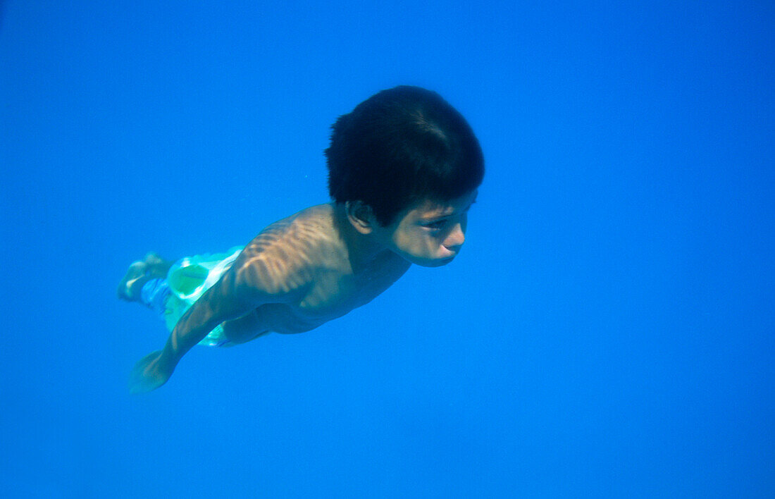Boy, fly, under water, Takapotu, Tuamotu Islands French Polynesia, South Pacific