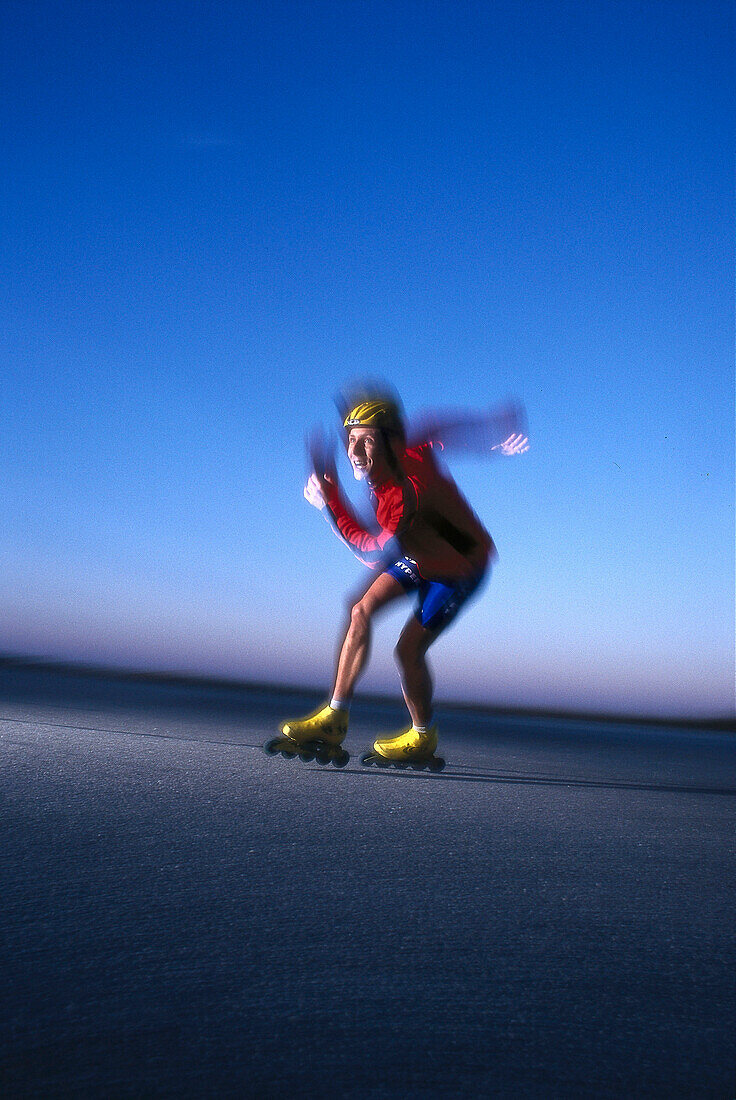 A man Inline skating in front of a blue sky