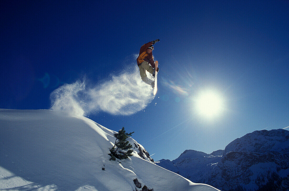 A snowboarder during a jump in front of a blue sky