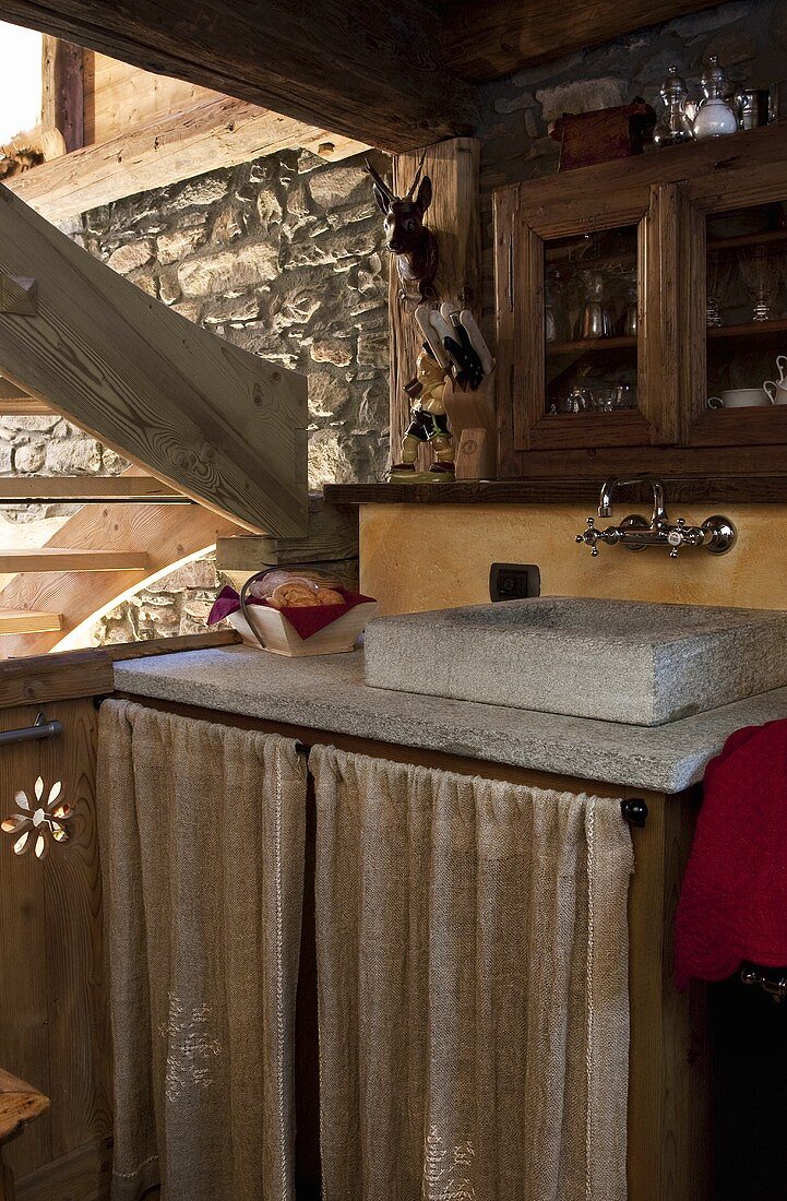 A stone wash basin in the kitchen corner of a rustic house