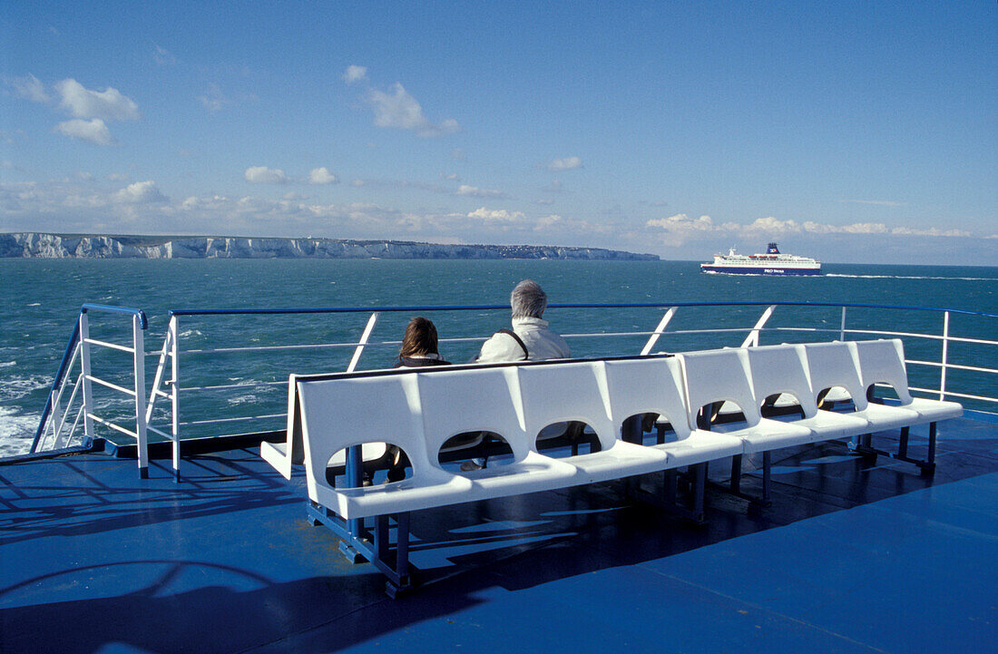 People on a ferry with view at the chalk cliffs of Dover, England