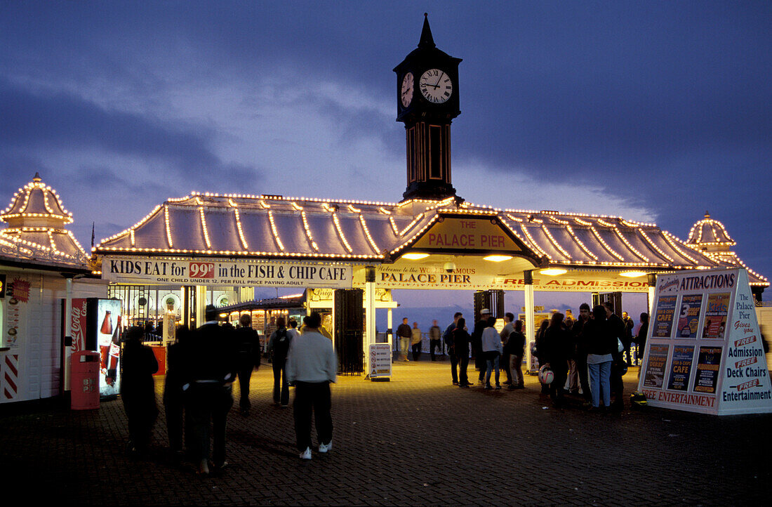 People at the illuminated Palace Pier at night, Brighton, Sussex, England